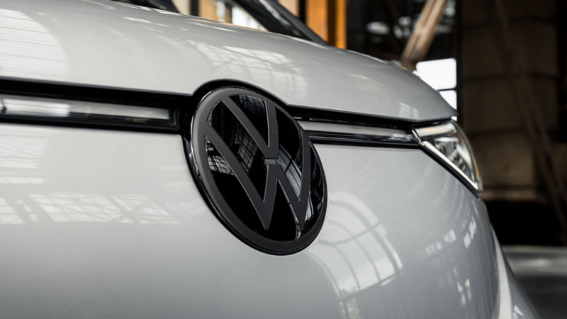 Glanzend zwart Volkswagen-logo op de motorkap van een zilveren ID. Buzz.