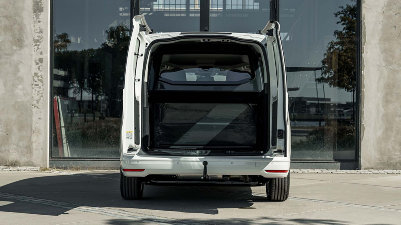 Caddy Kombi eHybrid to Cargo met geopende deuren en zichtbaar tussenschot en vlakke laadvloer van het Cargo Accessoire Pakket