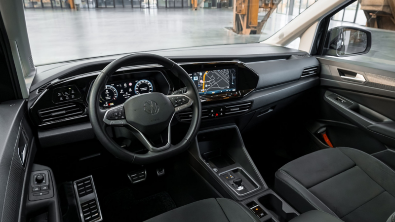 Interieur van een Volkswagen Caddy Kombi eHybrid toCargo met digitale cockpit, navigatiesysteem en een compacte automatische versnellingspook.