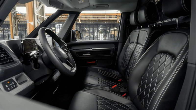 Interieur van een Volkswagen ID. Buzz met zwart lederen stoelen voorzien van een wit ruitvormig stikselpatroon.