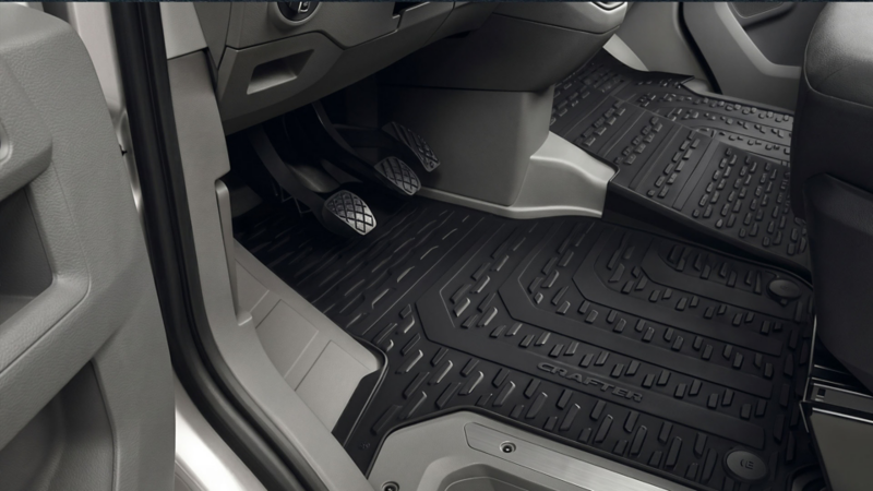 Zwarte rubberen automatten met reliëf en Crafter-opdruk in de voetenruimte van een Volkswagen bedrijfswagen.