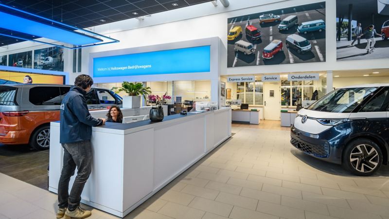 Klant die aan de balie staat in een Volkswagen Bedrijfswagens showroom