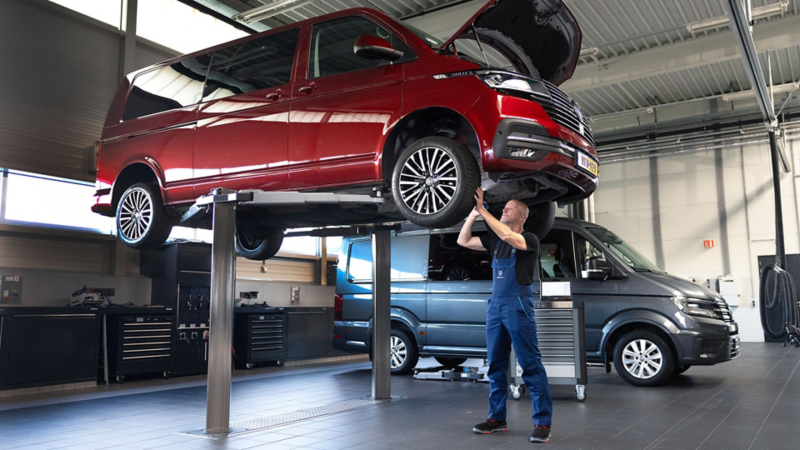 Monteur van Volkswagen Bedrijfswagens die een Transporter 6.1 aan het controleren is op de brug