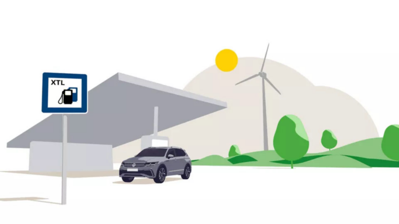 Illustratie van een Volkswagen bij een tankstation met XTL-bord in een groen landschap met windmolen.