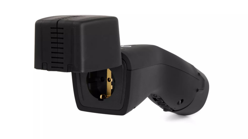 Zwarte Volkswagen V2L-adapter met een geopend klepje waarachter een 230V huishoudstopcontact zichtbaar is.