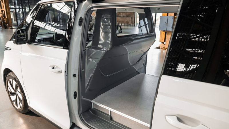 Interieur van een witte ID. Buzz toCargo met enkele cabine met zicht op de vlakke laadvloer en de grijze scheidingswand met ruit.