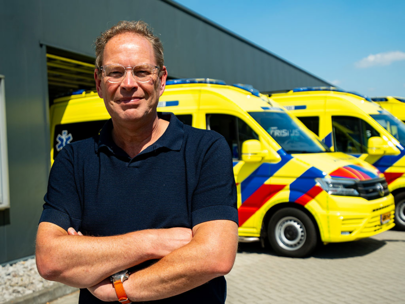 Sietze Kijlstra van Kijlstra Ambulancezorg en Zorgvervoer met op de achtergrond een drietal Volkswagen Crafters