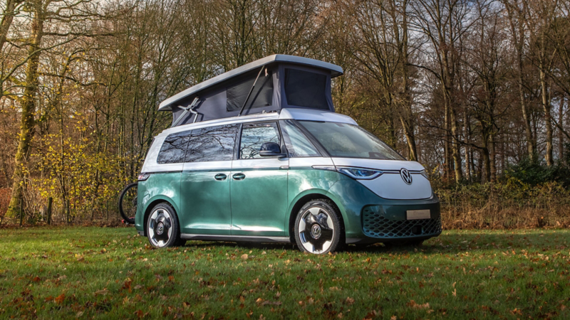 ID. Buzz camper van Outbase met geopend slaapdak aan de rand van het bos