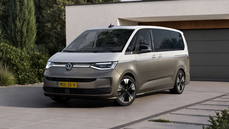 Tweekleurige Volkswagen Multivan in wit met metallic brons, geparkeerd op de strakke oprit van een modern huis.
