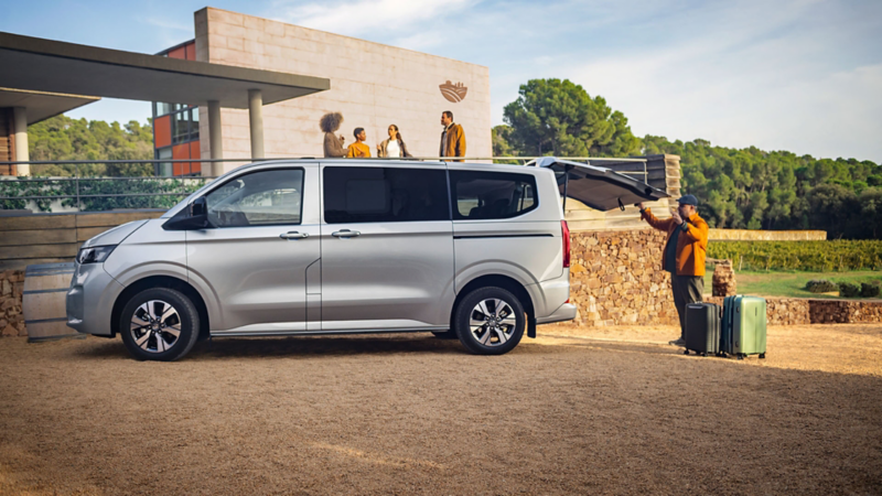 Nieuwe e-Caravelle met open achterklep en man die koffers inpakt