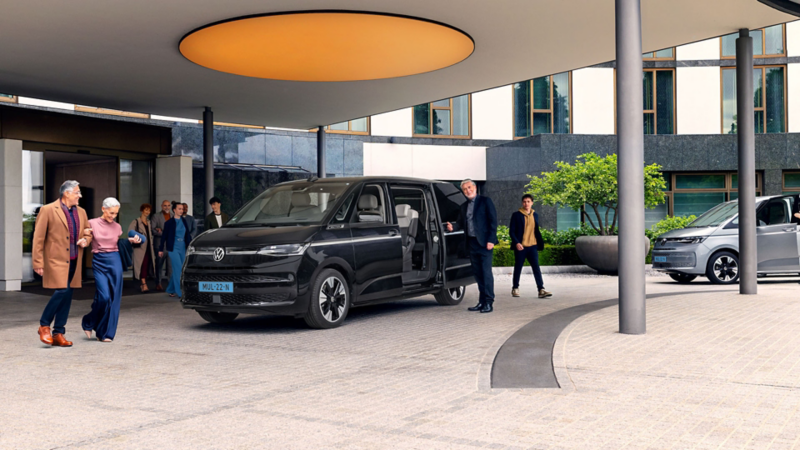 Twee Volkswagen Multivan eHybrids die worden ingezet als shuttle en een groep mensen komt ophalen