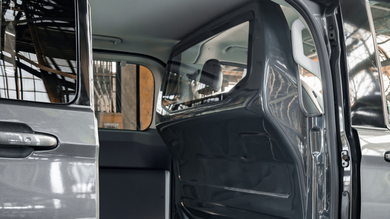 Interieur van een Volkswagen Transporter Kombi eHybrid toCargo met een kunststof scheidingswand inclusief ruit achter de voorstoelen.