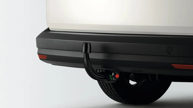 Afneembare trekhaak met beschermkap en ontgrendelknop, gemonteerd onder de achterbumper van een witte bedrijfswagen.