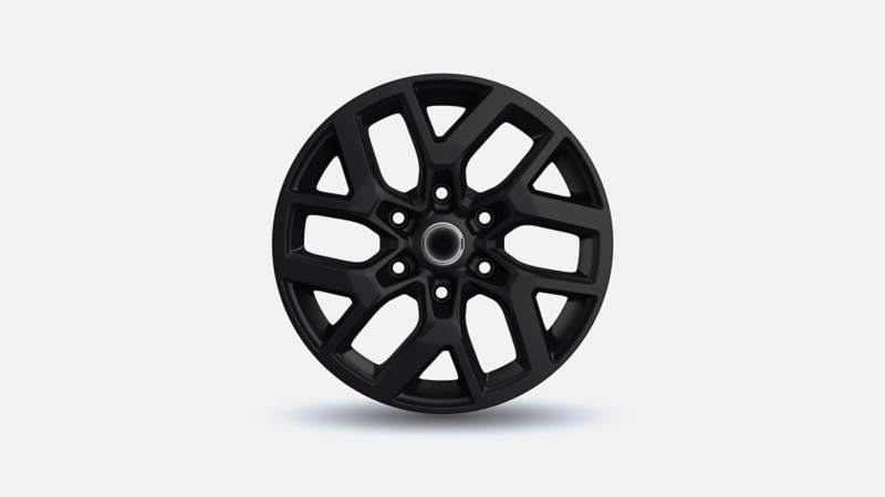 Mat zwarte lichtmetalen velg met een robuust vertakt spaakdesign voor de Volkswagen Transporter.