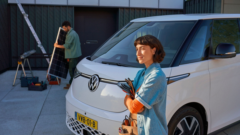Vrouw met kluskleding aan poserend naast de ID Buzz Cargo