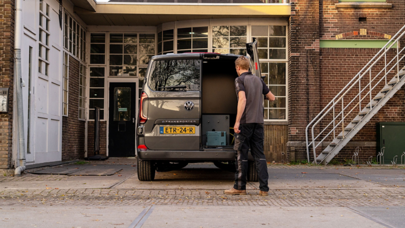 Persoon achter de nieuwe e-Transporter die één van de achterdeuren opent