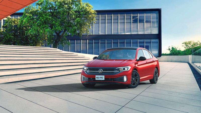Nuevo Jetta 2022. Auto familiar sedán Volkswagen en color rojo estacionado en una plaza.