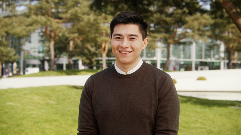 Young man in front of a Volkswagen building