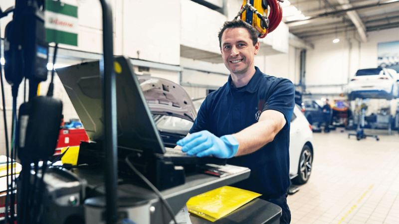 An engineer standing in a workshop on a laptop