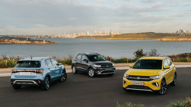 VW T-Cross range parked by the water with a background view of a city.