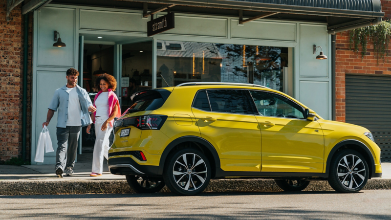 Woman opening the door of a Volkswagen T-Cross