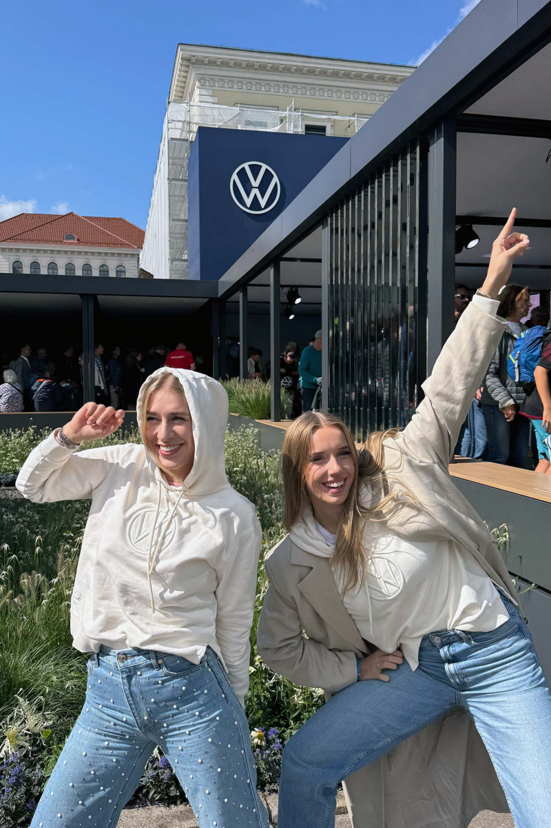 Zwei junge Frauen vor dem Volkswagen Stand auf der IAA in München