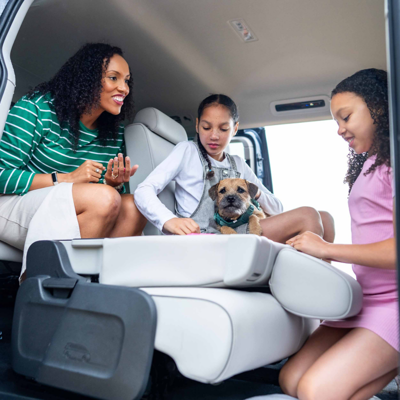 Family relaxing inside a Volkswagen ID. Buzz with a dog and flexible seating configuration