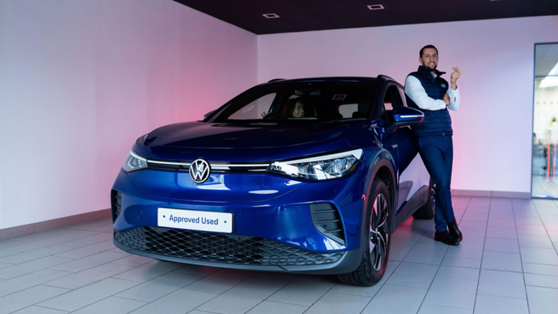 Sales Executive standing next to an Approved Used ID.4