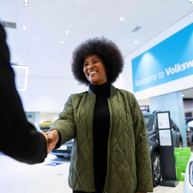 A customer being greeted at a Volkswagen used car retailer