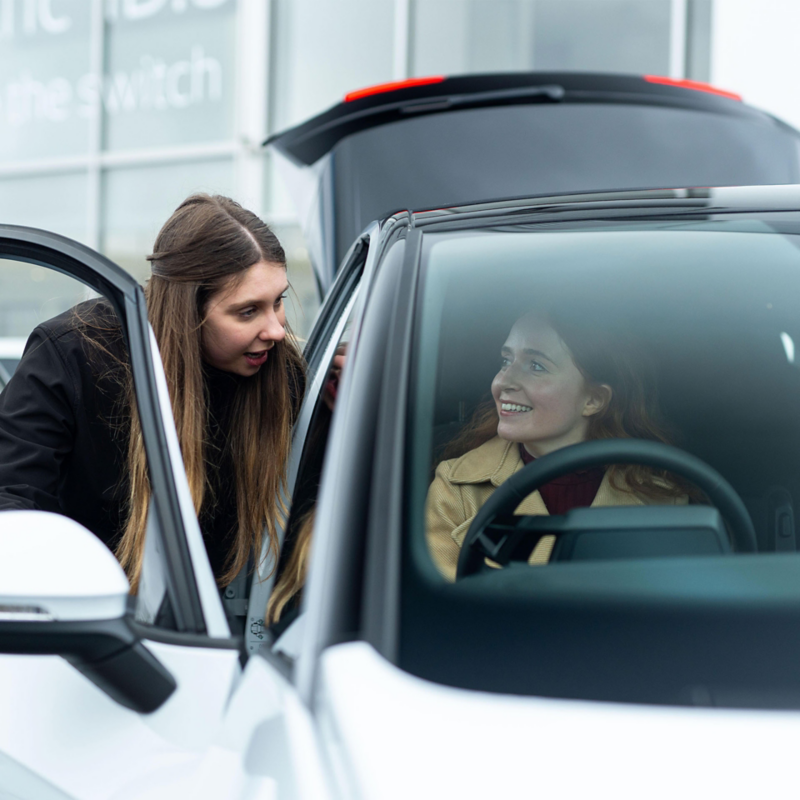 A customer being shown a used car at a VW retailer