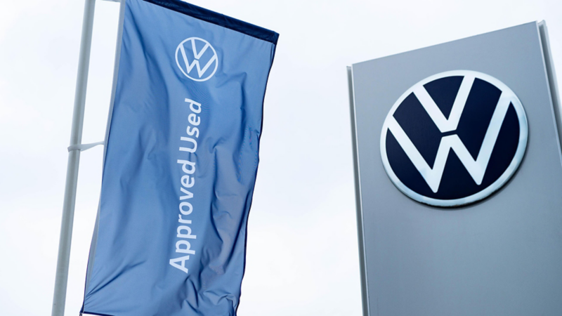 Volkswagen Approved Used flag and the VW signage at a retailer