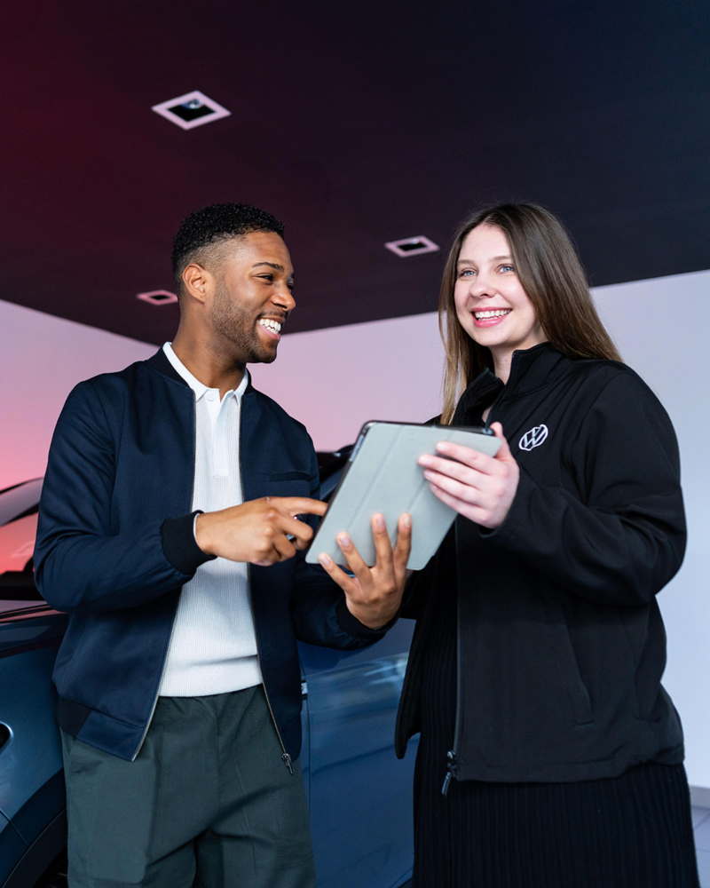 A customer being greeted at a Volkswagen used car retailer