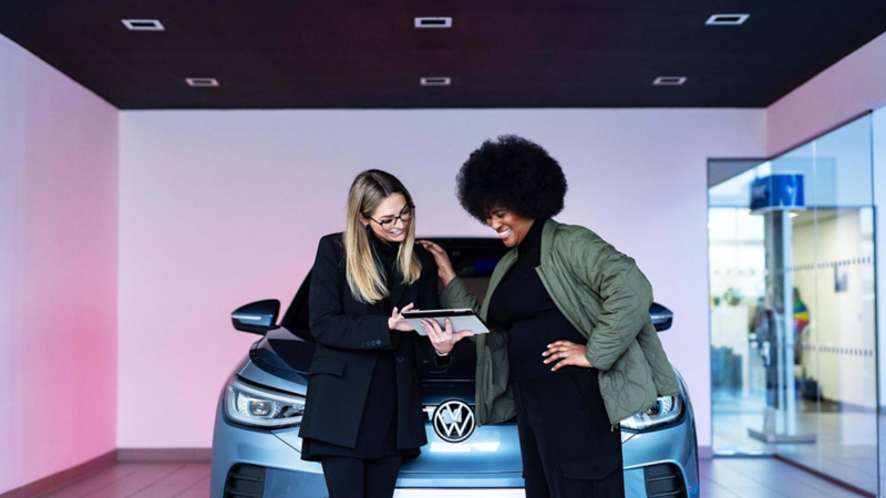 A woman assisting a customer at a Volkswagen Retailer