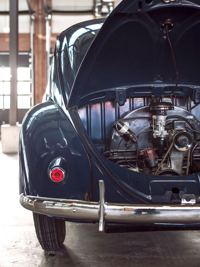 A detail shot of a historic Beetle with the rear hatch open to show the air-cooled engine.