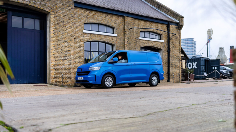 A blue Transporter Panel van parked at a construction site