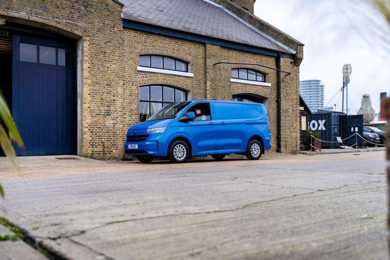 A blue Transporter Panel van parked against a brick walled building