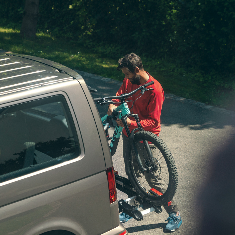 Un homme accroche son vélo sur le porte-vélo