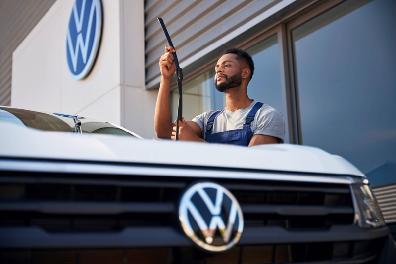 Un employé de Volkswagen travaille sur les essuie-glaces d'un véhicule Volkswagen