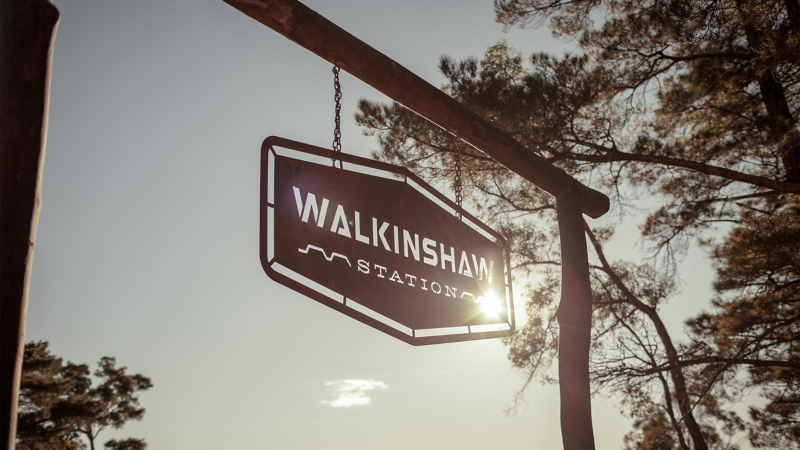 Walkinshaw Station sign hanging from gate to paddock