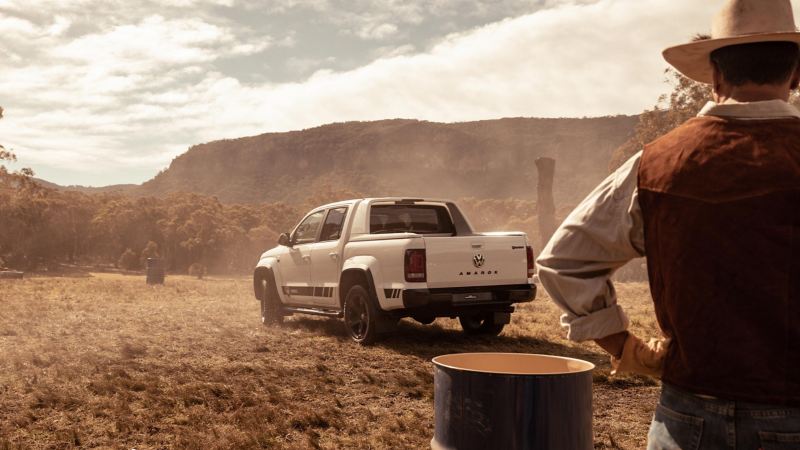 Volkswagen Amarok W-Series driving on paddock with farmer watching in foreground.