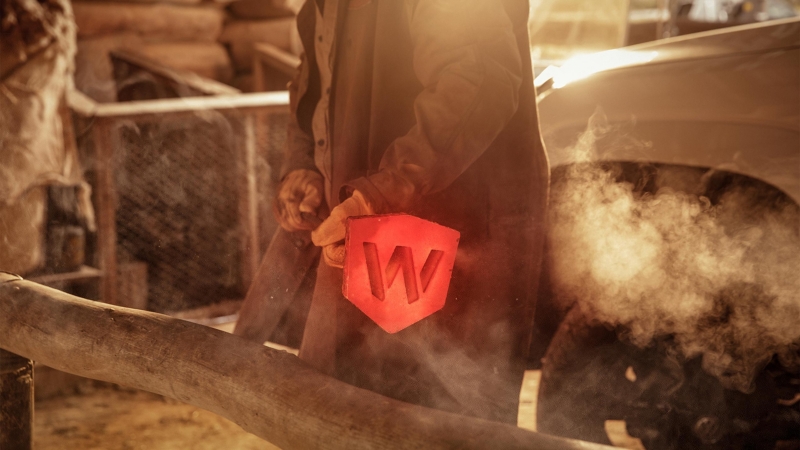 Farmer holding red hot branding hot-iron with Walkinshaw badge.