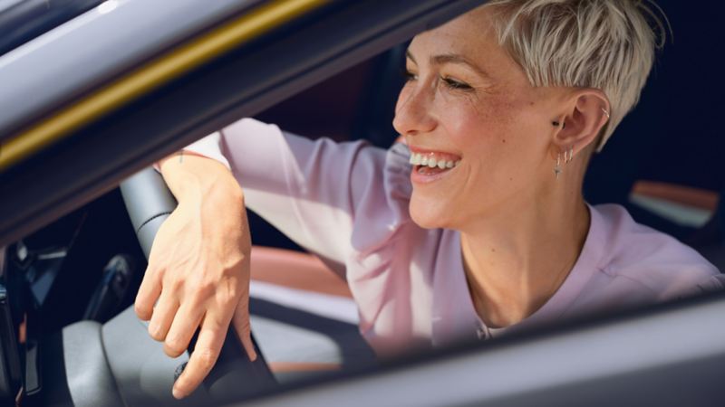 Une femme souriante dans un véhicule ID.4