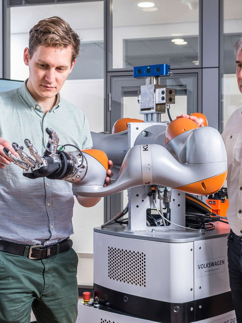 Zwei Mitarbeiter arbeiten an einer Robotorhand