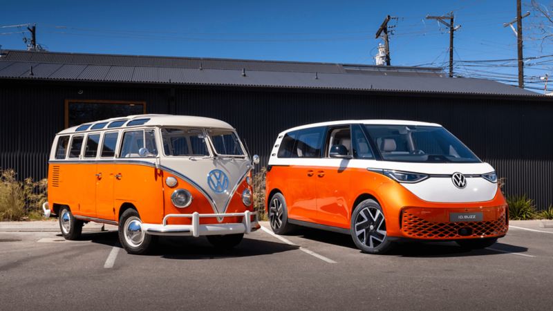 An orange ID.Buzz parked to an orange VW Microbus