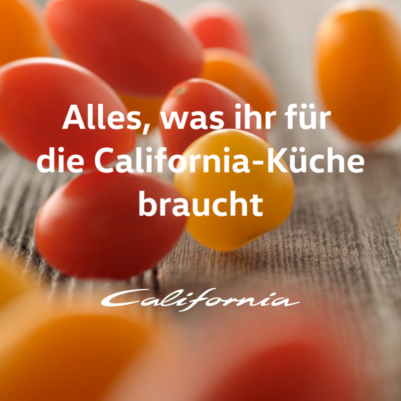 Rote und gelbe Cocktailtomaten fallen auf einen Tisch.