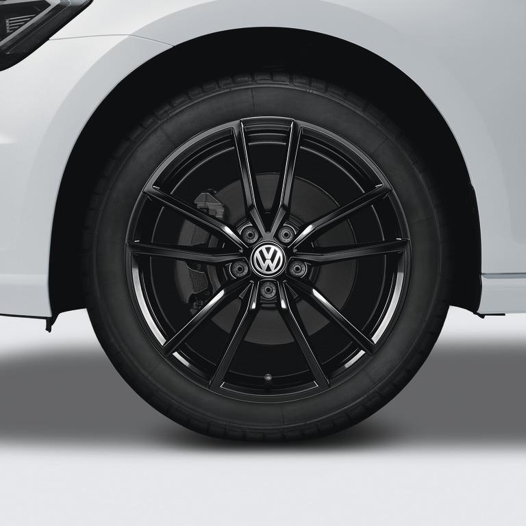 "Close-up of a black multi-spoke alloy wheel on a white Volkswagen vehicle. "