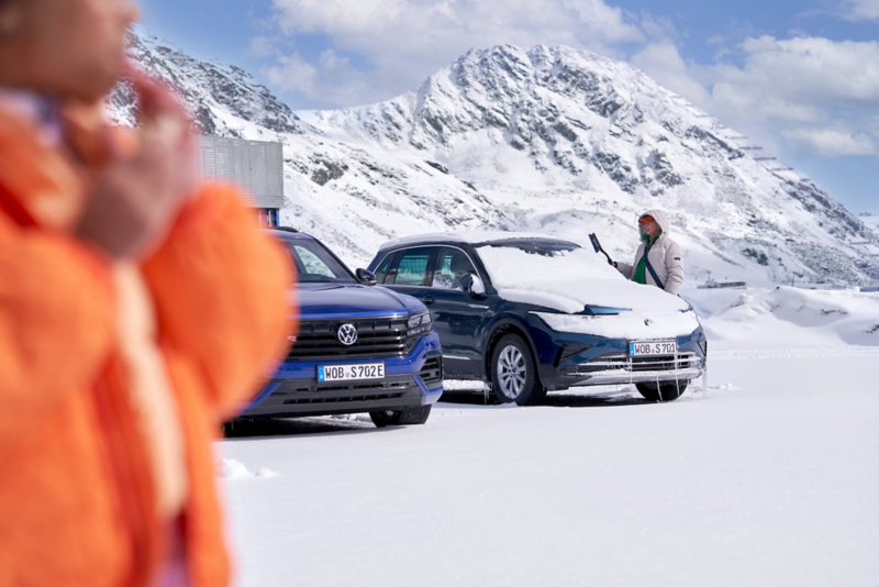 Två Volkswagen i en miljö med snötäckta berg. 