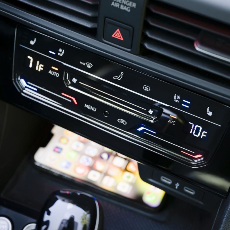 Close-up of the 2025 VW Jetta GLI's center console, highlighting the wireless device charging area beneath the climate controls.