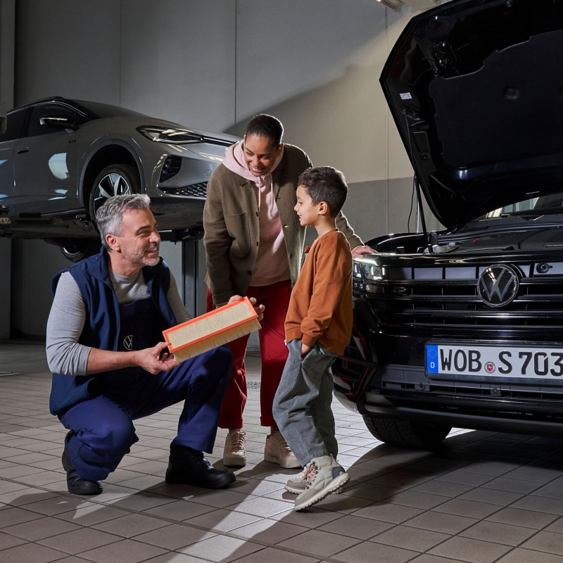 A VW service employee is advising a customer on windscreen wipers 