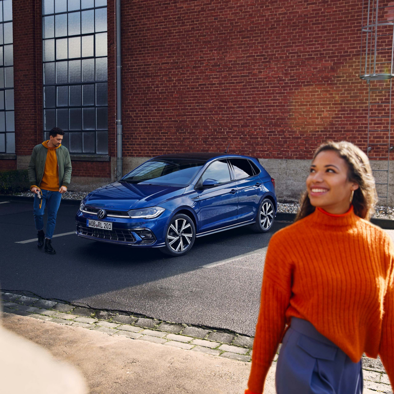 Woman walking away from Volkswagen car